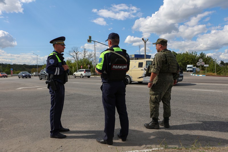 Seorang polisi lalu lintas Rusia berjaga di sebuah pos pemeriksaan di pinggiran kota, setelah rezim keamanan ketat diberlakukan di wilayah tersebut akibat serbuan pasukan Ukraina, selama konflik Rusia-Ukraina di Belgorod, Rusia, 12 Agustus 2024. (REUTERS/Stringer)