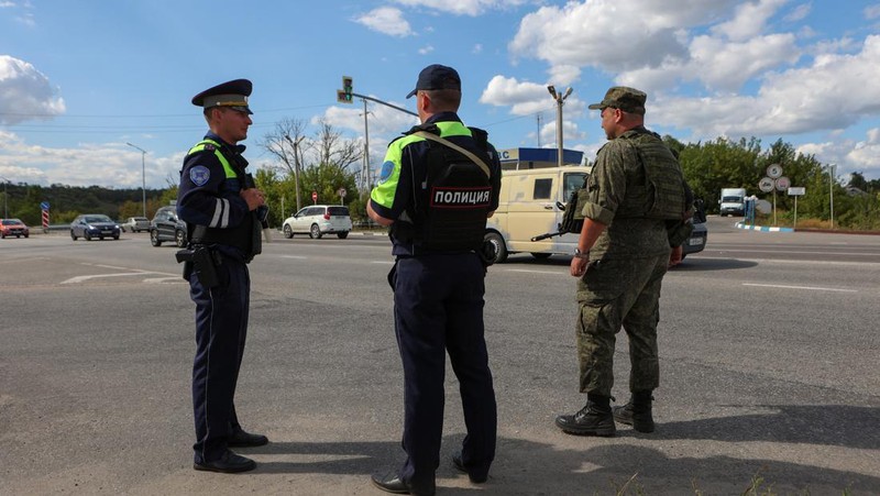 Seorang polisi lalu lintas Rusia berjaga di sebuah pos pemeriksaan di pinggiran kota, setelah rezim keamanan ketat diberlakukan di wilayah tersebut akibat serbuan pasukan Ukraina, selama konflik Rusia-Ukraina di Belgorod, Rusia, 12 Agustus 2024. (REUTERS/Stringer)