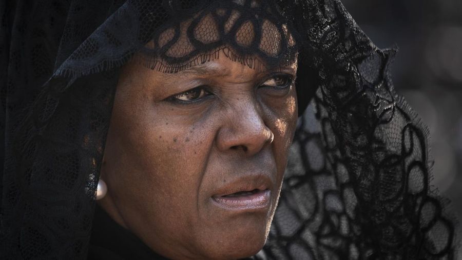 FILE- In this Thursday, Sept. 12, 2019, file photo, widow Grace Mugabe wears a black veil as she follows the casket of former president Robert Mugabe to an air force helicopter for transport to a stadium where it will lie in state, at his official residence in the capital Harare, Zimbabwe. Known as a strong-willed woman with political ambitions, Grace Mugabe rose from being one of the president’s secretaries to become first lady. (AP Photo/Ben Curtis, File)