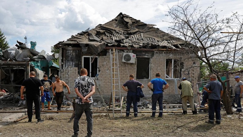 Penduduk setempat berjalan melewati sebuah rumah yang hancur akibat penembakan baru-baru ini, yang oleh otoritas setempat yang dibentuk Rusia disebut sebagai serangan militer Ukraina, selama konflik Rusia-Ukraina di Horlivka (Gorlovka) di wilayah Donetsk, Ukraina yang dikuasai Rusia, 15 Agustus 2024. (REUTERS/Alexander Ermochenko)