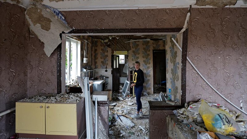 Penduduk setempat berjalan melewati sebuah rumah yang hancur akibat penembakan baru-baru ini, yang oleh otoritas setempat yang dibentuk Rusia disebut sebagai serangan militer Ukraina, selama konflik Rusia-Ukraina di Horlivka (Gorlovka) di wilayah Donetsk, Ukraina yang dikuasai Rusia, 15 Agustus 2024. (REUTERS/Alexander Ermochenko)
