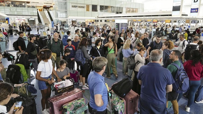 Penumpang terlihat di terminal penerbangan internasional di bandara Haneda, Tokyo, Jepang, saat topan kuat mendekati wilayah Tokyo, Jumat, 16 Agustus 2024. (Kyodo News via AP)