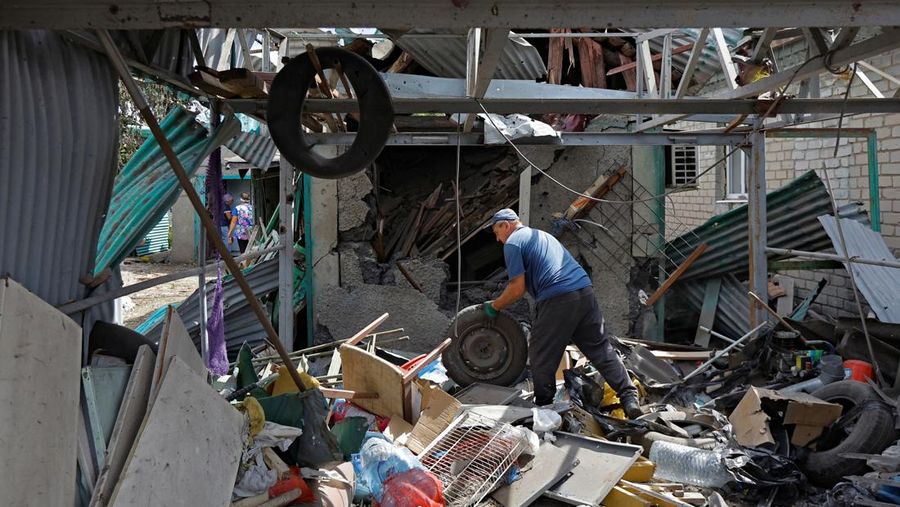 Penduduk setempat berjalan melewati sebuah rumah yang hancur akibat penembakan baru-baru ini, yang oleh otoritas setempat yang dibentuk Rusia disebut sebagai serangan militer Ukraina, selama konflik Rusia-Ukraina di Horlivka (Gorlovka) di wilayah Donetsk, Ukraina yang dikuasai Rusia, 15 Agustus 2024. (REUTERS/Alexander Ermochenko)
