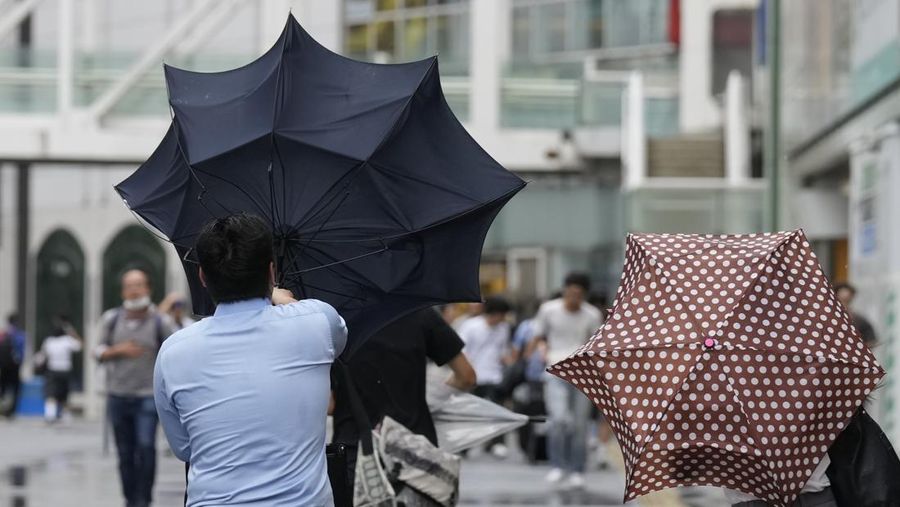 Seorang pria dengan payung berjuang melawan angin kencang yang dibawa oleh Topan Ampil, saat berjalan di jalan, di Tokyo, Jepang, Jumat, 16 Agustus 2024. (AP Photo/Hiro Komae)