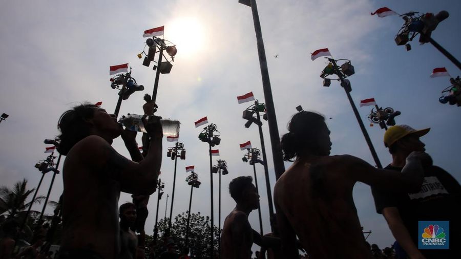 Warga mengikuti lomba panjat pinang kolosal dalam rangka HUT Ke-79 Kemerdekaan RI di Pantai Ancol, Jakarta, Sabtu (17/8/2024). (CNBC Indonesia/Faisal Rahman)