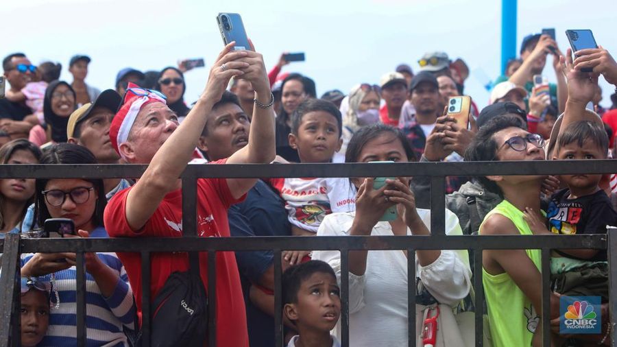 Warga mengikuti lomba panjat pinang kolosal dalam rangka HUT Ke-79 Kemerdekaan RI di Pantai Ancol, Jakarta, Sabtu (17/8/2024). (CNBC Indonesia/Faisal Rahman)
