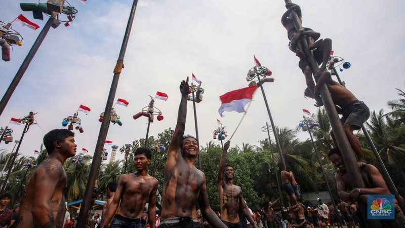 Warga mengikuti lomba panjat pinang kolosal dalam rangka HUT Ke-79 Kemerdekaan RI di Pantai Ancol, Jakarta, Sabtu (17/8/2024). (CNBC Indonesia/Faisal Rahman)