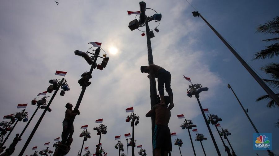 Warga mengikuti lomba panjat pinang kolosal dalam rangka HUT Ke-79 Kemerdekaan RI di Pantai Ancol, Jakarta, Sabtu (17/8/2024). (CNBC Indonesia/Faisal Rahman)
