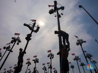 Warga mengikuti lomba panjat pinang kolosal dalam rangka HUT Ke-79 Kemerdekaan RI di Pantai Ancol, Jakarta, Sabtu (17/8/2024). (CNBC Indonesia/Faisal Rahman)