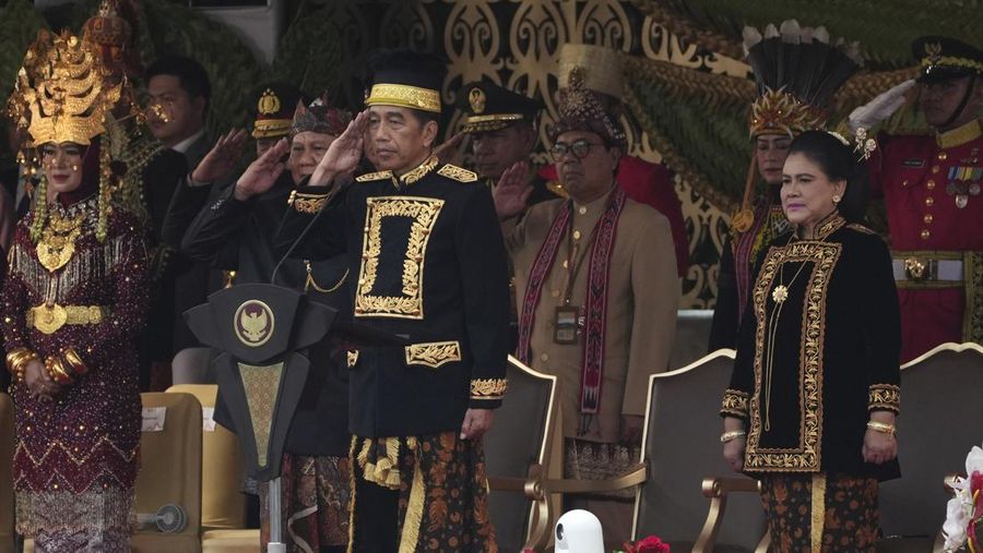 Presiden Indonesia Joko Widodo, tengah, didampingi istrinya Iriana, kanan, memberi hormat selama upacara peringatan HUT ke-79 kemerdekaan Indonesia di Istana Negara Ibu Kota Nusantara (IKN), Kalimantan Timur, Sabtu (17/8/2024). (AP Photo/Achmad Ibrahim)
