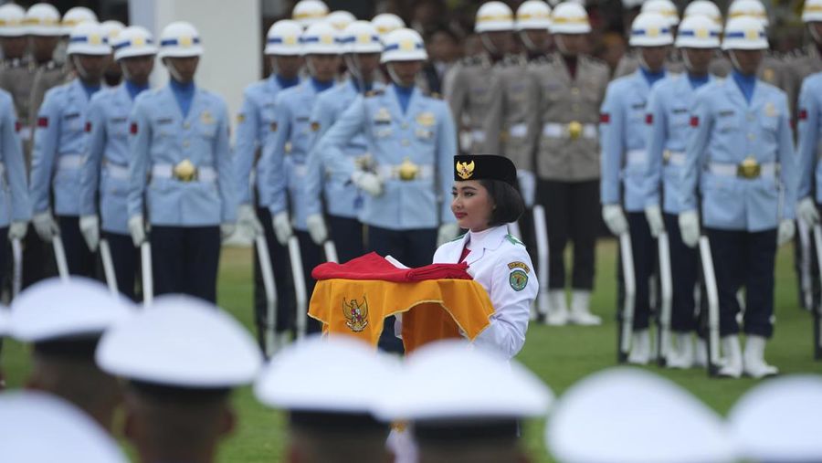 Seorang pembawa membawa bendera nasional Merah Putih yang akan dikibarkan selama upacara peringatan HUT ke-79 kemerdekaan Indonesia di Istana Negara, Ibu Kota Nusantara (IKN), Kalimantan Timur, Sabtu (17/8/2024). (AP Photo/Achmad Ibrahim)