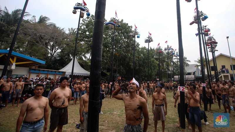 Warga mengikuti lomba panjat pinang kolosal dalam rangka HUT Ke-79 Kemerdekaan RI di Pantai Ancol, Jakarta, Sabtu (17/8/2024). (CNBC Indonesia/Faisal Rahman)