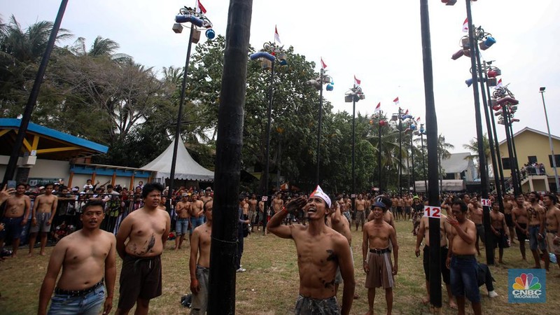 Warga mengikuti lomba panjat pinang kolosal dalam rangka HUT Ke-79 Kemerdekaan RI di Pantai Ancol, Jakarta, Sabtu (17/8/2024). (CNBC Indonesia/Faisal Rahman)