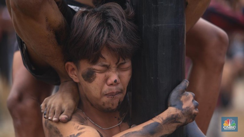 Warga mengikuti lomba panjat pinang kolosal dalam rangka HUT Ke-79 Kemerdekaan RI di Pantai Ancol, Jakarta, Sabtu (17/8/2024). (CNBC Indonesia/Faisal Rahman)