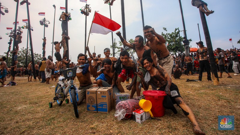 Warga mengikuti lomba panjat pinang kolosal dalam rangka HUT Ke-79 Kemerdekaan RI di Pantai Ancol, Jakarta, Sabtu (17/8/2024). (CNBC Indonesia/Faisal Rahman)