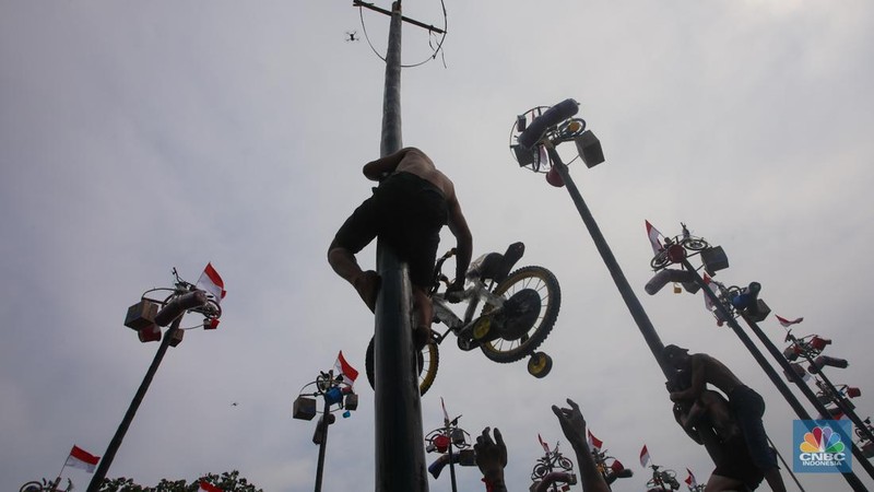 Warga mengikuti lomba panjat pinang kolosal dalam rangka HUT Ke-79 Kemerdekaan RI di Pantai Ancol, Jakarta, Sabtu (17/8/2024). (CNBC Indonesia/Faisal Rahman)