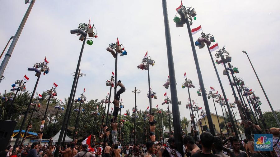 Warga mengikuti lomba panjat pinang kolosal dalam rangka HUT Ke-79 Kemerdekaan RI di Pantai Ancol, Jakarta, Sabtu (17/8/2024). (CNBC Indonesia/Faisal Rahman)