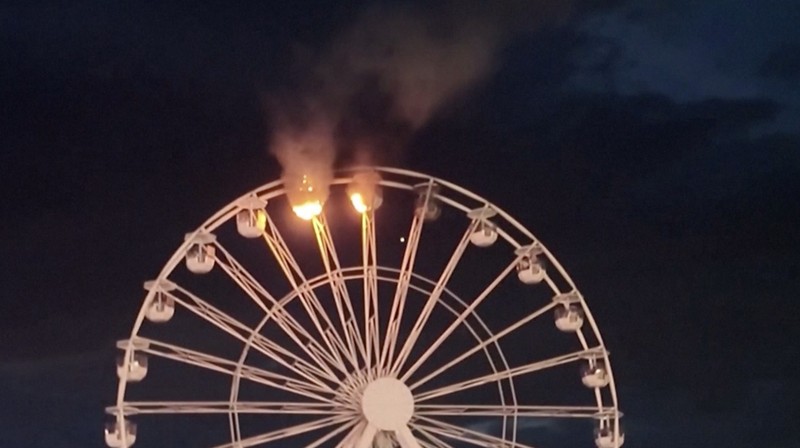 Petugas pemadam kebakaran berupaya memadamkan api di bianglala festival musik di Jerman pada Sabtu (17/8/2024), yang mengakibatkan sedikitnya lima orang terluka. Petugas pemadam kebakaran berupaya memadamkan api di bianglala festival musik di Jerman pada Sabtu (17/8/2024), yang mengakibatkan sedikitnya lima orang terluka. (Tangkapan Layar Video Reuters/Newss)