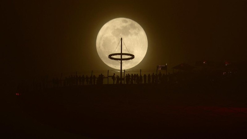 Supermoon langka muncul di atas pelabuhan kargo di utara ibu kota Indonesia, Jakarta, pada hari Senin (19 Agustus), menandai supermoon pertama tahun ini. (Reuters/)