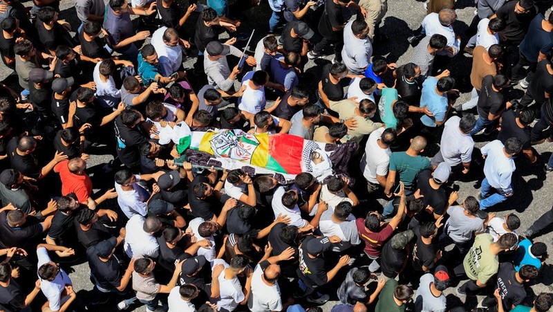 Para pelayat membawa jenazah seorang warga Palestina berusia 18 tahun saat prosesi pemakaman di Dura, Tepi Barat, Selasa (20/8/2024). (REUTERS/Mussa Qawasma)