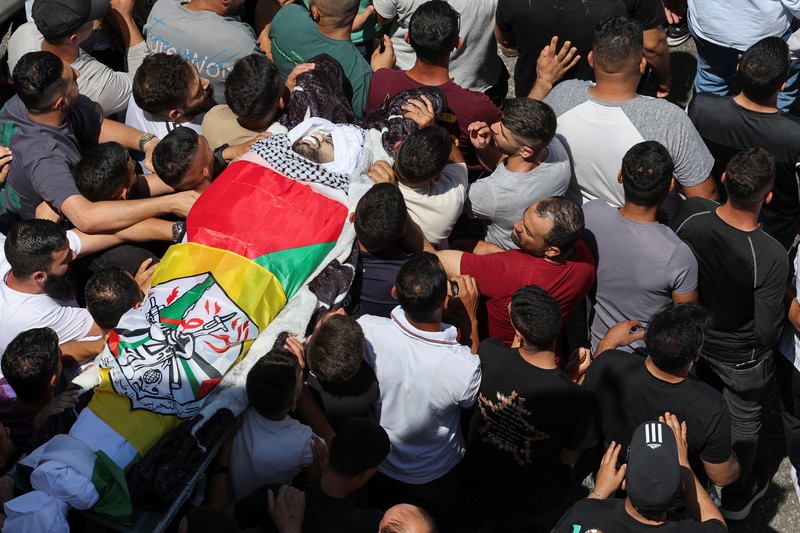 Para pelayat membawa jenazah seorang warga Palestina berusia 18 tahun saat prosesi pemakaman di Dura, Tepi Barat, Selasa (20/8/2024). (REUTERS/Mussa Qawasma)