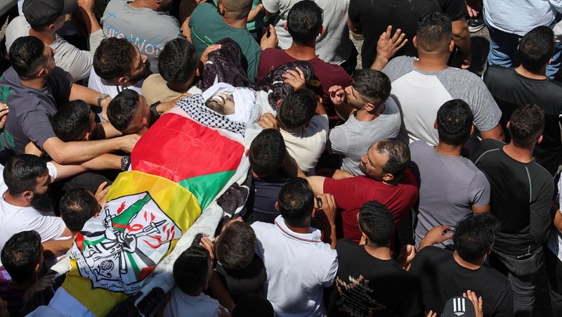 Para pelayat membawa jenazah seorang warga Palestina berusia 18 tahun saat prosesi pemakaman di Dura, Tepi Barat, Selasa (20/8/2024). (REUTERS/Mussa Qawasma)