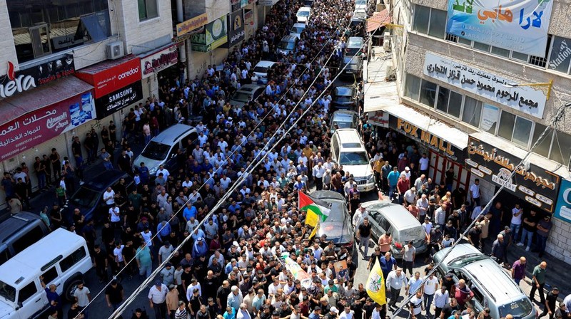 Para pelayat membawa jenazah seorang warga Palestina berusia 18 tahun saat prosesi pemakaman di Dura, Tepi Barat, Selasa (20/8/2024). (REUTERS/Mussa Qawasma)