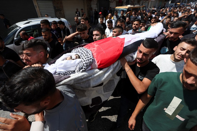 Para pelayat membawa jenazah seorang warga Palestina berusia 18 tahun saat prosesi pemakaman di Dura, Tepi Barat, Selasa (20/8/2024). (REUTERS/Mussa Qawasma) Para pelayat membawa jenazah seorang warga Palestina berusia 18 tahun saat prosesi pemakaman di Dura, Tepi Barat, Selasa (20/8/2024). (REUTERS/Mussa Qawasma)