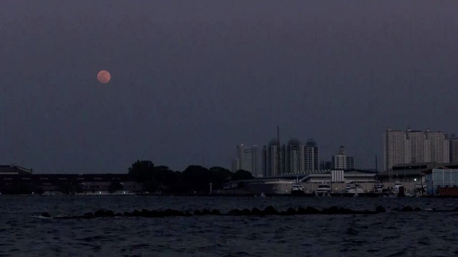 Supermoon langka muncul di atas pelabuhan kargo di utara ibu kota Indonesia, Jakarta, pada hari Senin (19 Agustus), menandai supermoon pertama tahun ini. (Reuters/)