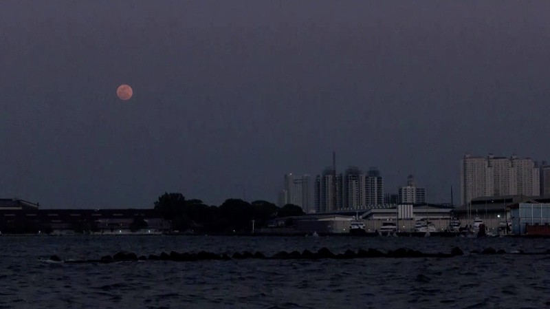 Supermoon langka muncul di atas pelabuhan kargo di utara ibu kota Indonesia, Jakarta, pada hari Senin (19 Agustus), menandai supermoon pertama tahun ini. (Reuters/)