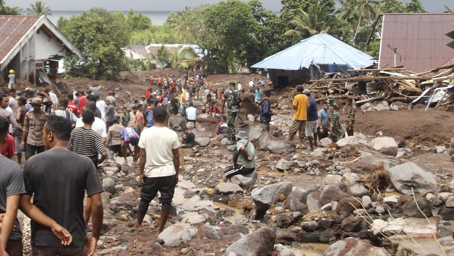 Petugas penyelamat dan warga desa mencari orang hilang setelah banjir bandang yang menewaskan sejumlah orang di Rua, Pulau Ternate, Maluku Utara, Minggu (25/8/2024). (AP Photo/Rifki Anwar)