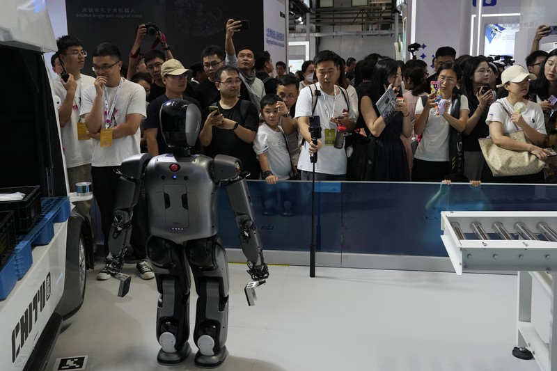 Seorang pekerja berjalan melewati berbagai jenis robot mirip manusia di Konferensi Robot Dunia yang diadakan di Beijing, Rabu, 21 Agustus 2024. Seorang pekerja berjalan melewati berbagai jenis robot mirip manusia di Konferensi Robot Dunia yang diadakan di Beijing, Rabu, 21 Agustus 2024. (AP Photo/Ng Han Guan)