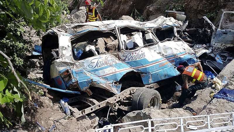 Relawan mengevakuasi jenazah dan penumpang yang terluka dari bus yang rusak akibat jatuh ke jurang, dekat Kahuta, Pakistan, Minggu, 25 Agustus 2024. (AP Photo)
