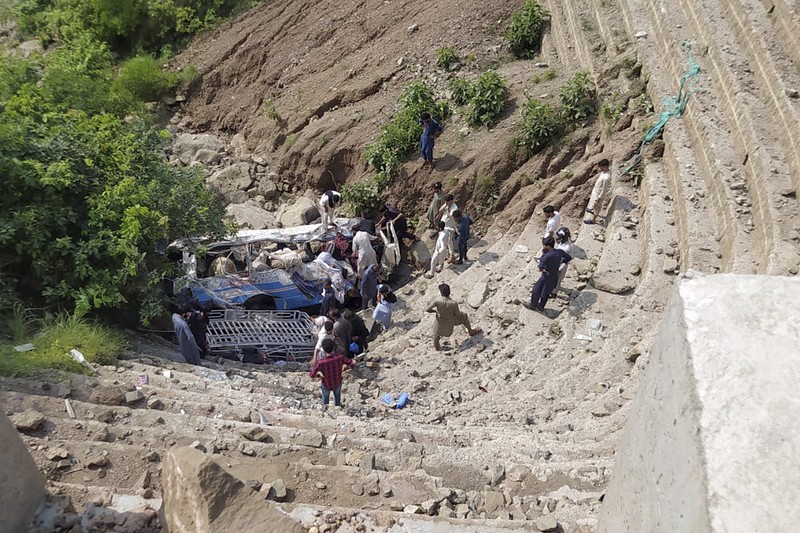 Relawan mengevakuasi jenazah dan penumpang yang terluka dari bus yang rusak akibat jatuh ke jurang, dekat Kahuta, Pakistan, Minggu, 25 Agustus 2024. (AP Photo)