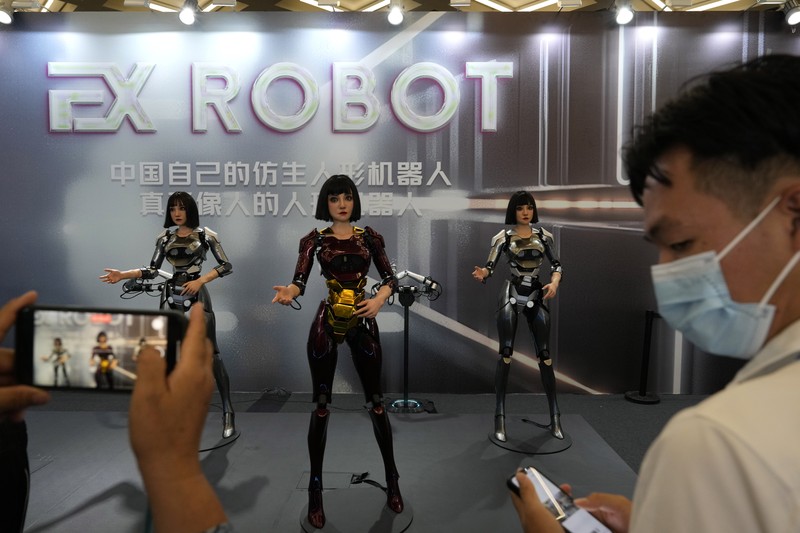 Seorang pekerja berjalan melewati berbagai jenis robot mirip manusia di Konferensi Robot Dunia yang diadakan di Beijing, Rabu, 21 Agustus 2024. Seorang pekerja berjalan melewati berbagai jenis robot mirip manusia di Konferensi Robot Dunia yang diadakan di Beijing, Rabu, 21 Agustus 2024. (AP Photo/Ng Han Guan)
