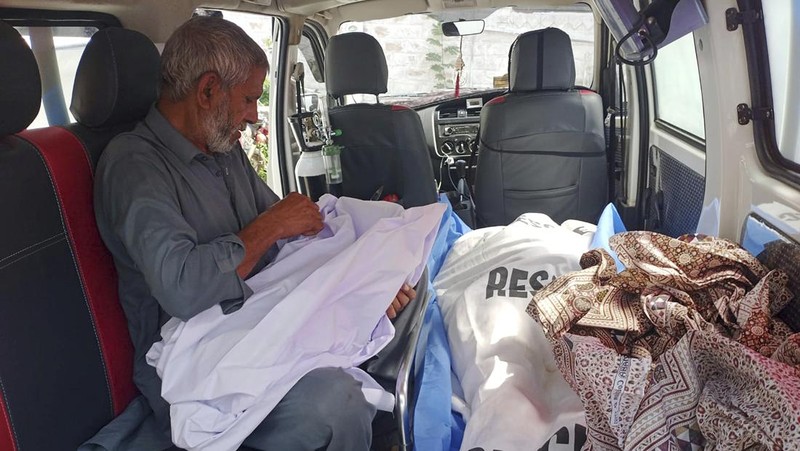 Relawan mengevakuasi jenazah dan penumpang yang terluka dari bus yang rusak akibat jatuh ke jurang, dekat Kahuta, Pakistan, Minggu, 25 Agustus 2024. (AP Photo)