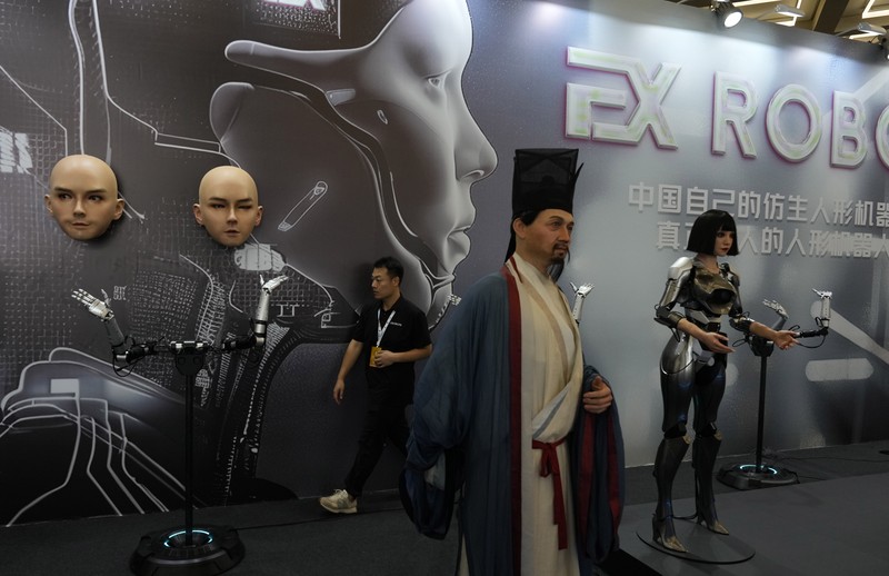 Seorang pekerja berjalan melewati berbagai jenis robot mirip manusia di Konferensi Robot Dunia yang diadakan di Beijing, Rabu, 21 Agustus 2024. Seorang pekerja berjalan melewati berbagai jenis robot mirip manusia di Konferensi Robot Dunia yang diadakan di Beijing, Rabu, 21 Agustus 2024. (AP Photo/Ng Han Guan)