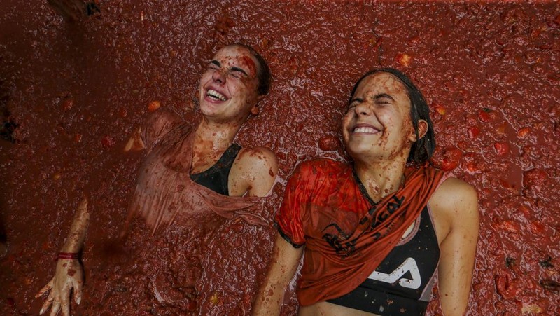 Para pengunjung saling melempar tomat selama pesta pertarungan tomat tahunan 