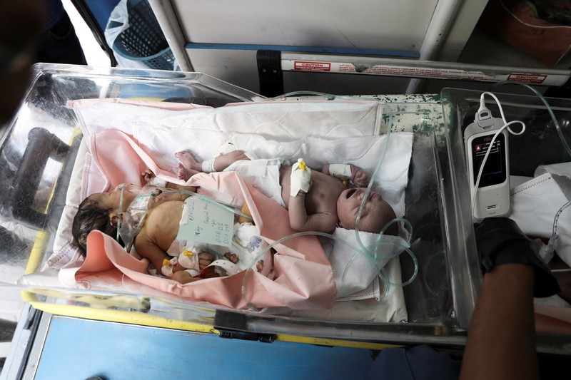 Petugas membawa bayi-bayi prematur Palestina yang dievakuasi dari Rumah Sakit Al-Aqsa ke Rumah Sakit Nasser Khan Younis, menyusul perintah evakuasi untuk wilayah sekitar Rumah Sakit Al-Aqsa di tengah konflik Israel-Hamas, di Deir Al-Balah di Jalur Gaza tengah, 26 Agustus 2024. (REUTERS/Abd elhkeem Khaled)