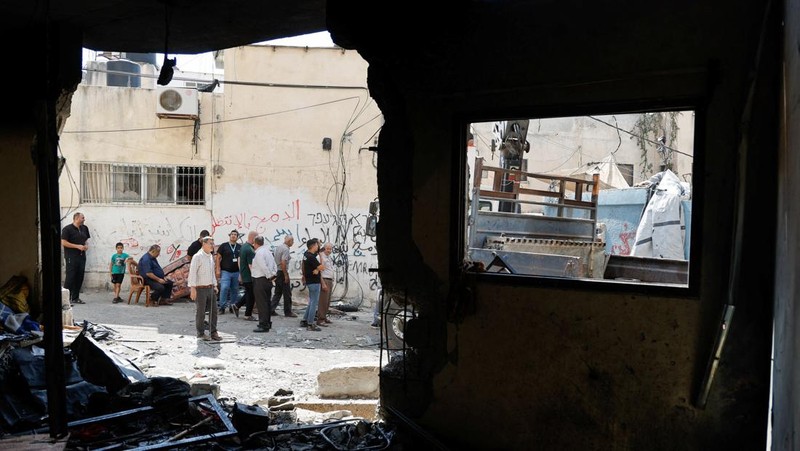 Palestinians stand outside a heavily damaged mosque following an Israeli military operation in the West Bank refugee camp of Al-Faraa, Thursday, Aug. 29, 2024. (AP Photo/Nasser Nasser)