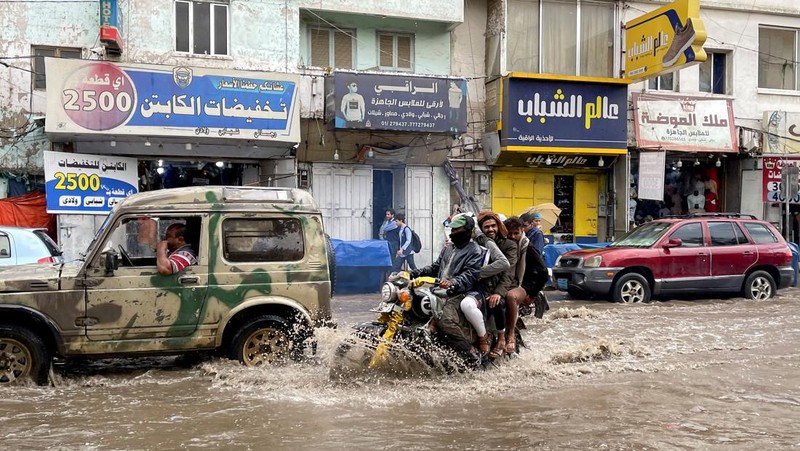 Seorang pria menyeberangi jalan yang banjir saat hujan lebat di Sanaa, Yaman, 28 Agustus 2024. (REUTERS/Khaled Abdullah)