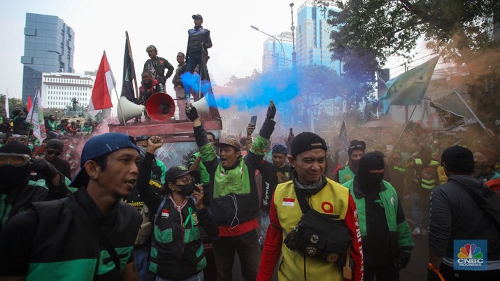 Sejumlah pengemudi ojek online melakukan bakar ban saat aksi unjuk rasa di kawasan Patung Kuda Arjuna Wijaya, Jakarta, Kamis (29/8/2024). (CNBC Indonesia/Faisal Rahman)