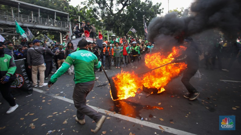 Sejumlah pengemudi ojek online melakukan bakar ban saat aksi unjuk rasa di kawasan Patung Kuda Arjuna Wijaya, Jakarta, Kamis (29/8/2024). (CNBC Indonesia/Faisal Rahman)