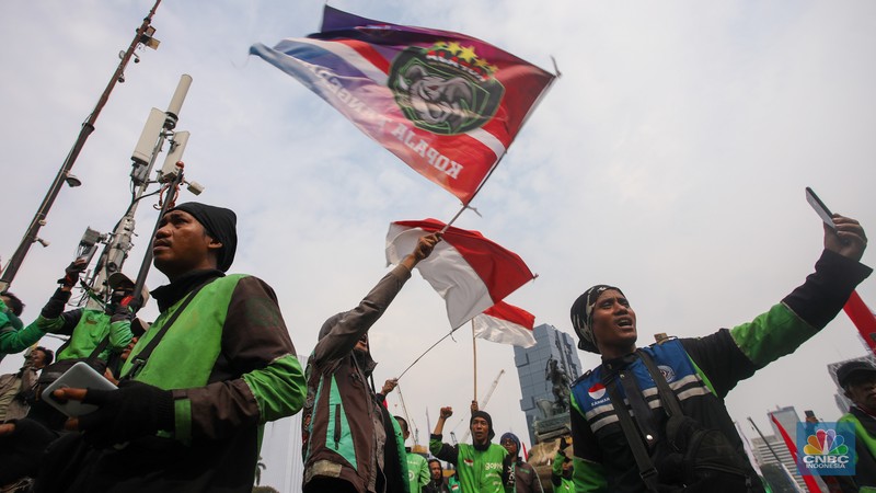 Sejumlah pengemudi ojek online melakukan bakar ban saat aksi unjuk rasa di kawasan Patung Kuda Arjuna Wijaya, Jakarta, Kamis (29/8/2024). (CNBC Indonesia/Faisal Rahman)