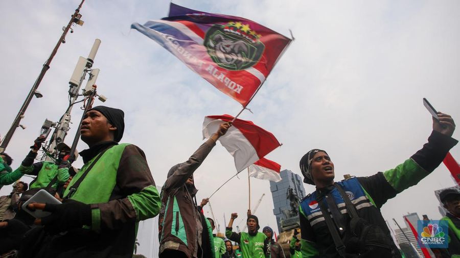 Sejumlah pengemudi ojek online melakukan bakar ban saat aksi unjuk rasa di kawasan Patung Kuda Arjuna Wijaya, Jakarta, Kamis (29/8/2024). (CNBC Indonesia/Faisal Rahman)