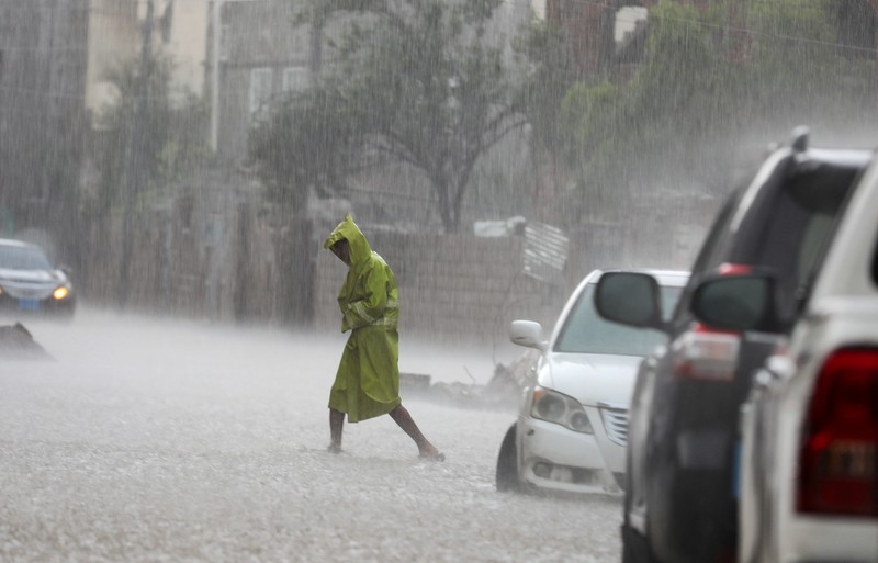 Seorang pria menyeberangi jalan yang banjir saat hujan lebat di Sanaa, Yaman, 28 Agustus 2024. Seorang pria menyeberangi jalan yang banjir saat hujan lebat di Sanaa, Yaman, 28 Agustus 2024. (REUTERS/Khaled Abdullah)