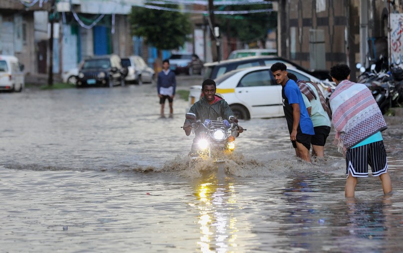 Seorang pria menyeberangi jalan yang banjir saat hujan lebat di Sanaa, Yaman, 28 Agustus 2024. Seorang pria menyeberangi jalan yang banjir saat hujan lebat di Sanaa, Yaman, 28 Agustus 2024. (REUTERS/Khaled Abdullah)