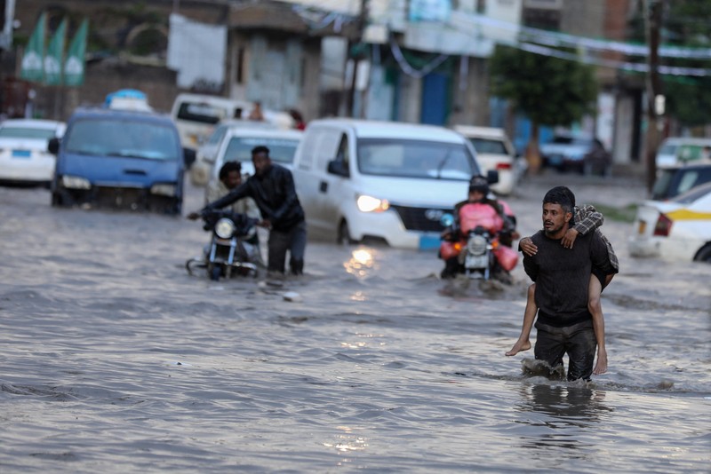 Seorang pria menyeberangi jalan yang banjir saat hujan lebat di Sanaa, Yaman, 28 Agustus 2024. Seorang pria menyeberangi jalan yang banjir saat hujan lebat di Sanaa, Yaman, 28 Agustus 2024. (REUTERS/Khaled Abdullah)