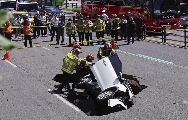 A vehicle that fell into a sinkhole is seen on a street in Seoul, South Korea, Thursday, Aug. 29, 2024. (Seo Dae-yeon/Yonhap via AP)
