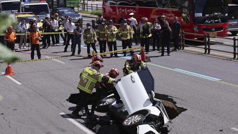 A vehicle that fell into a sinkhole is seen on a street in Seoul, South Korea, Thursday, Aug. 29, 2024. (Seo Dae-yeon/Yonhap via AP)